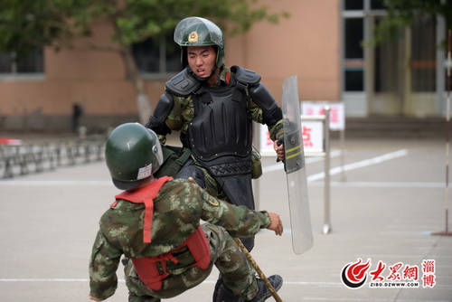 警棍盾牌擒敌考核.手持木棍的"暴徒"没有几个回合便被制服了.