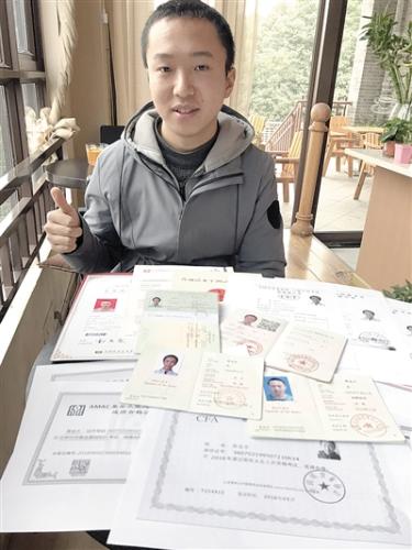 黄金水给记者展示大学期间所考的证书,给自己加油本报记者 黄晔闵 